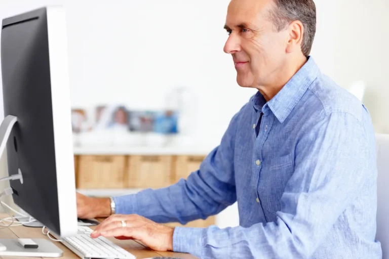 Homme travaillant sur son ordinateur de bureau, chez lui