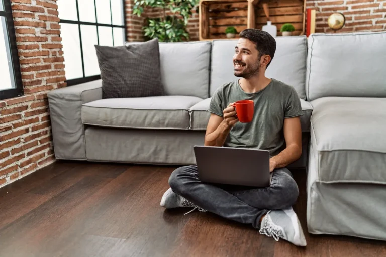 Jeune homme consultant son ordinateur chez lui