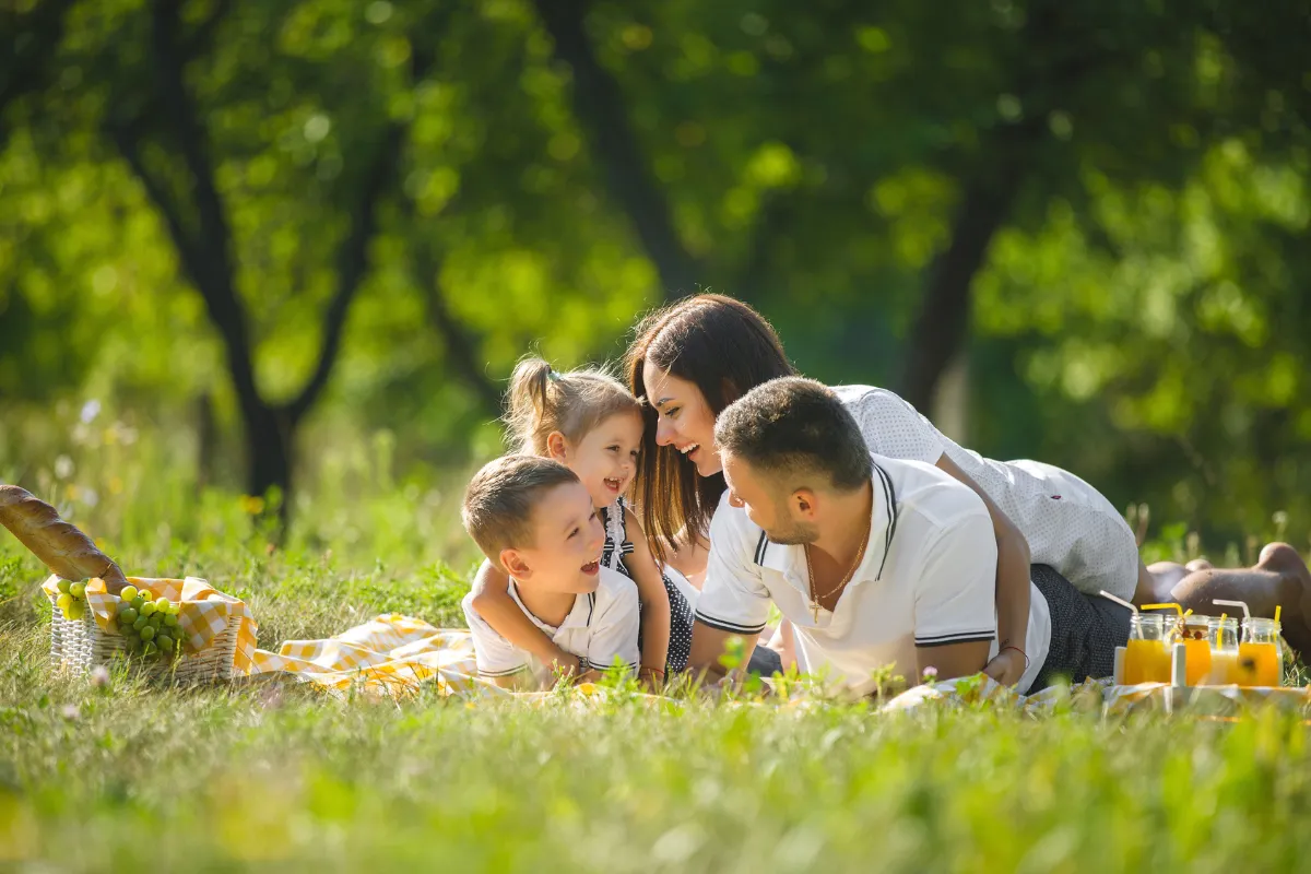 Famille allongée dans l’herbe lors d’un pique-nique